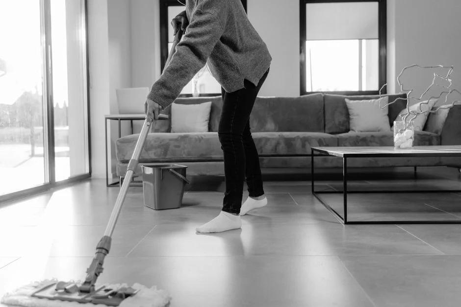 Person using spray bottle and cloth for cleaning a kitchen shelf, ensuring hygiene and cleanliness.